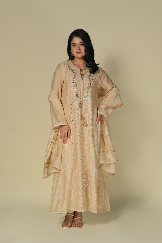 A woman wearing an ecru-colored Mukaish Mul Chanderi suit set with delicate embroidery and a dupatta.