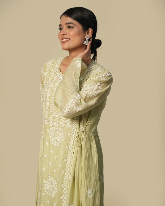 A woman wearing a green floral print kurta set with chikankari work