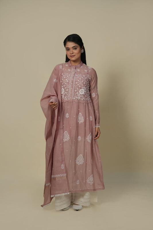 A woman wearing a mauve A-line suit set with embroidery and a dupatta.