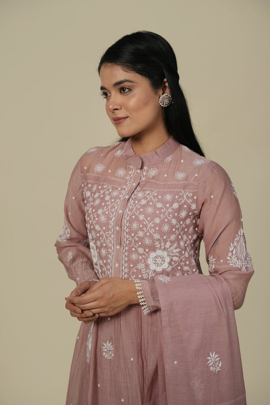 A woman wearing a mauve A-line suit set with embroidery and a dupatta.