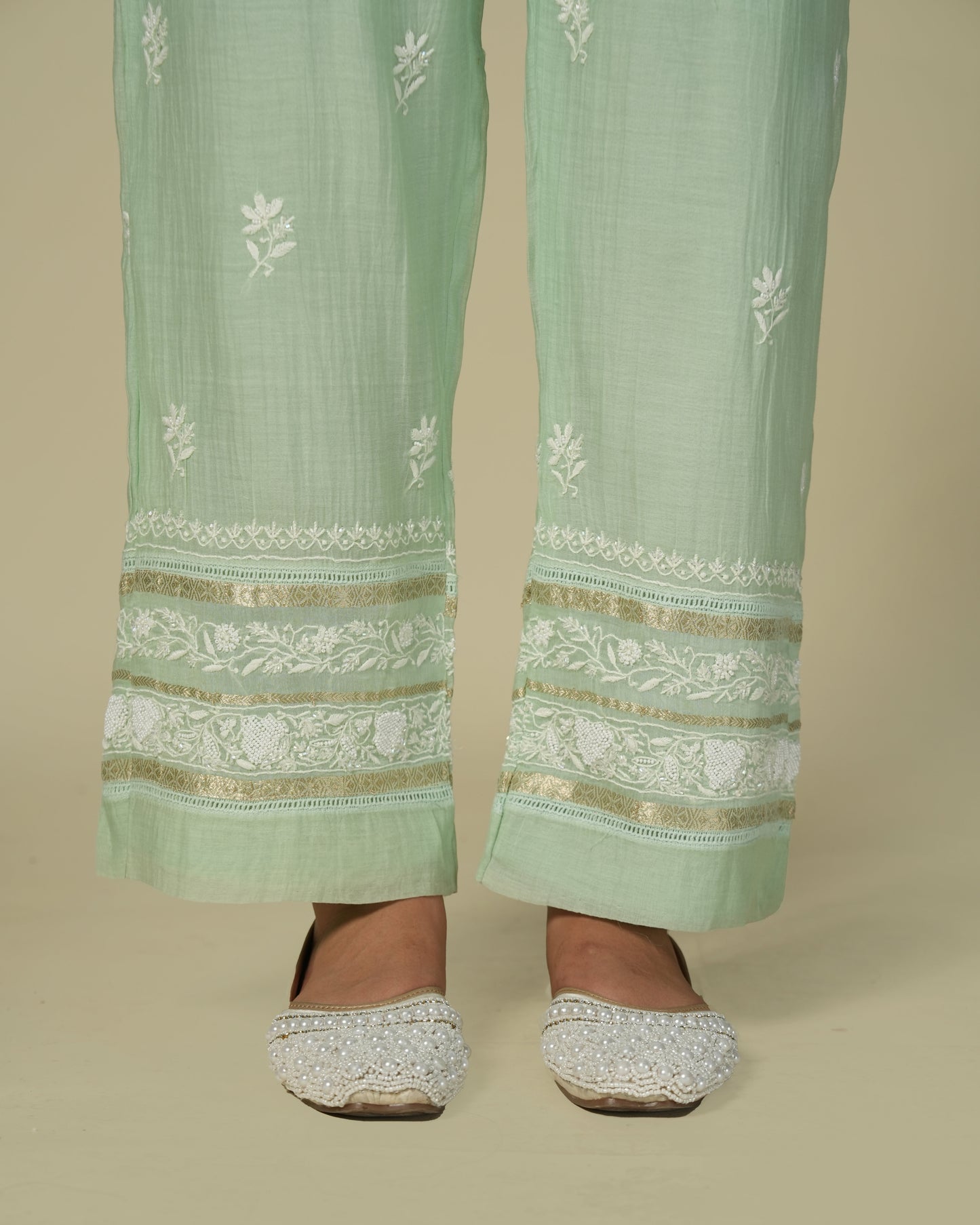 Close up of model wearing green chikankari and chanderi palazzo pants.