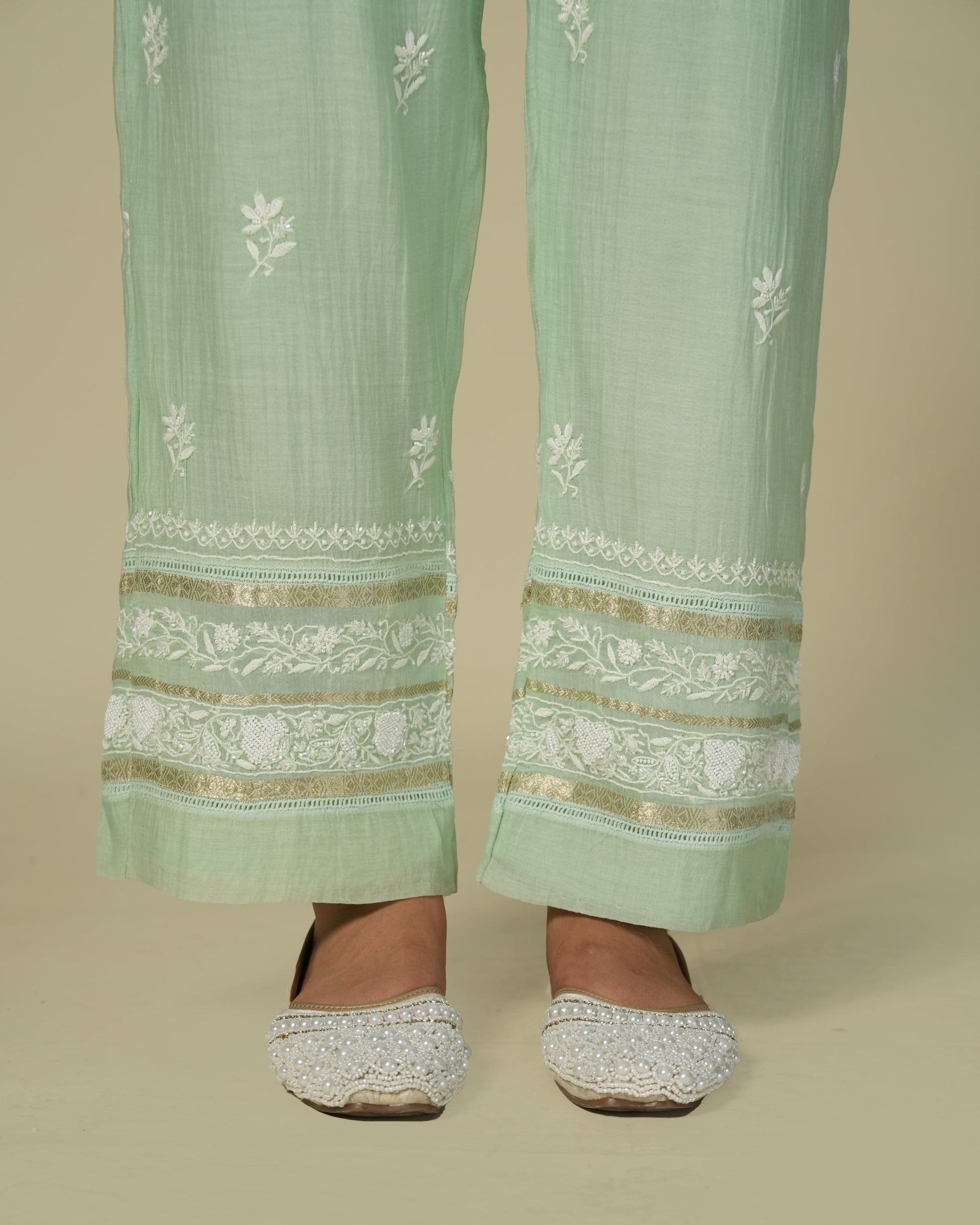 Close up of model wearing green chikankari and chanderi palazzo pants.